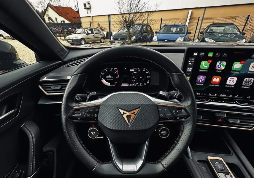Vue intérieure centrée sur le volant cuir noir perforé avec logo CUPRA et tableau de bord digital du Formentor gris.