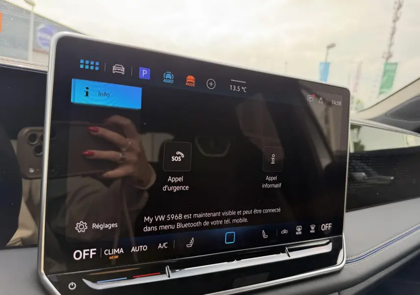 Écran tactile central du Volkswagen Tiguan 2025 affichant les options d'appel d'urgence et réglages, intérieur gris.