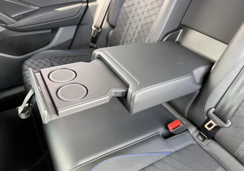 Accoudoir central arrière déployé avec porte-gobelets dans l'habitacle gris du Volkswagen Tiguan 2025.