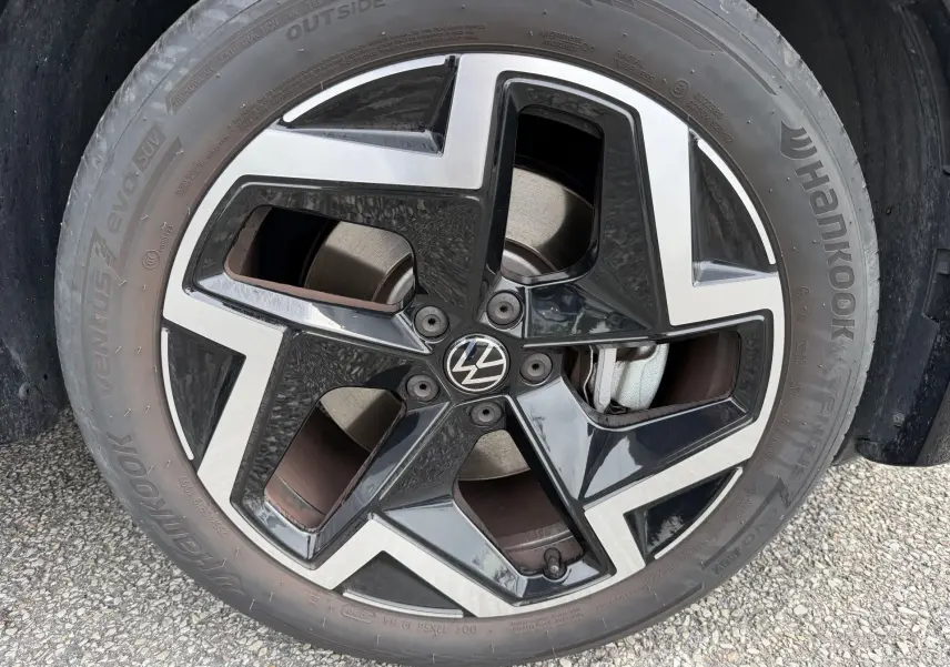 Gros plan sur la jante noire et argentée 19 pouces du Volkswagen Tiguan 2025 avec logo VW au centre.