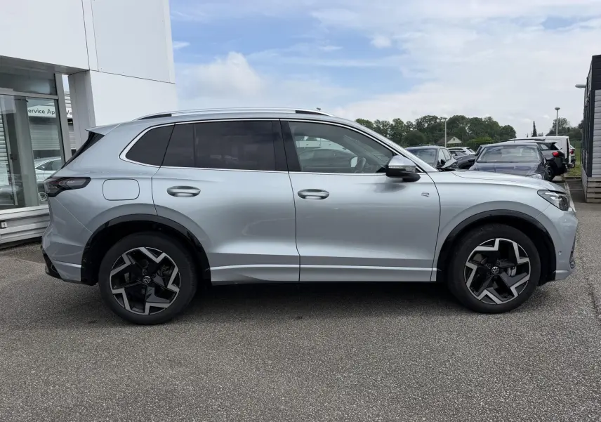 Vue latérale droite d'un Volkswagen Tiguan gris 2025 avec jantes alliage noires et vitres teintées.