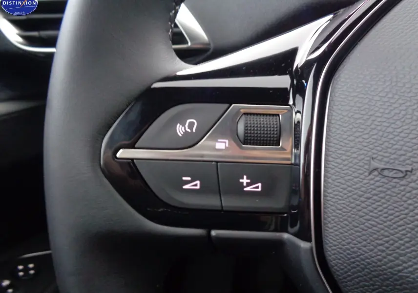 Gros plan sur les commandes du volant noir du Peugeot 3008 gris platinium, mettant en valeur les boutons de volume et appel.