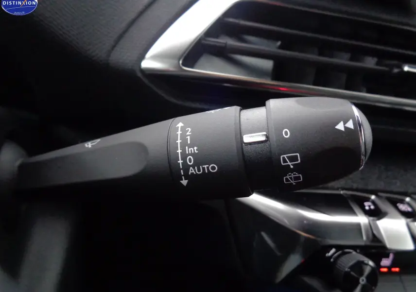 Gros plan sur la commande d'essuie-glace du Peugeot 3008 gris platinium, avec marquages blancs et finition intérieure noire.