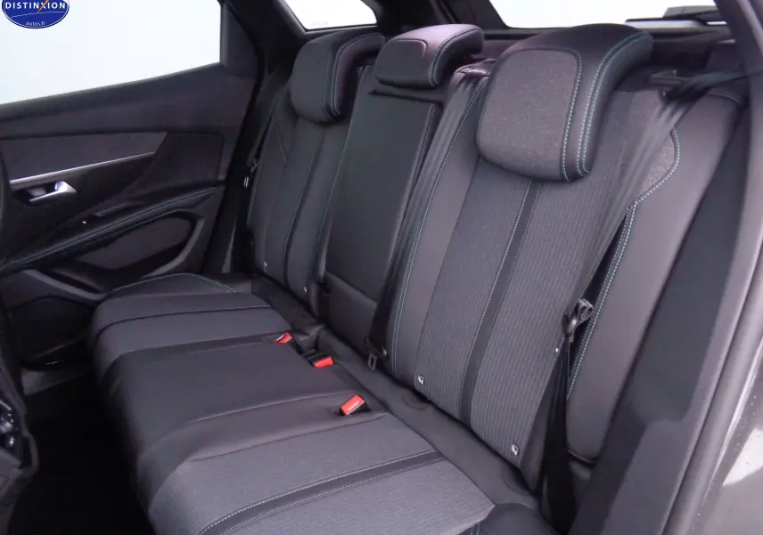 Vue intérieure arrière droite des sièges arrière en cuir noir et tissu gris avec surpiqûres bleues du Peugeot 3008 2023 gris platinium.