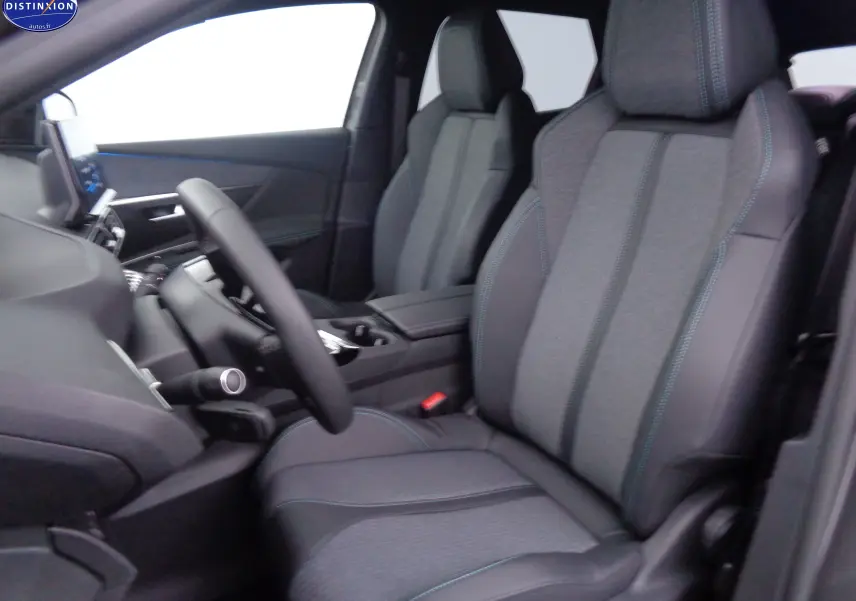 Vue intérieure côté conducteur du Peugeot 3008 2023 avec sièges tissu et cuir noir aux surpiqûres bleues.