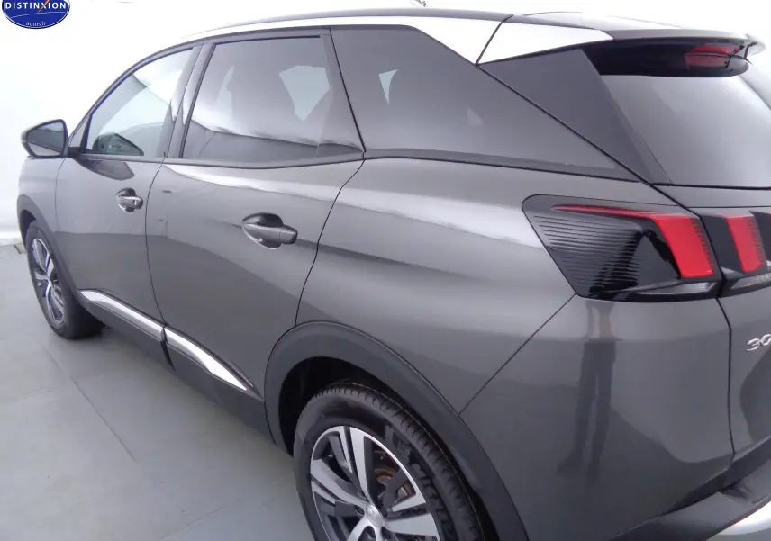 Vue 3/4 arrière côté gauche d'un Peugeot 3008 gris platinium métal avec feux arrière à LED distinctifs.