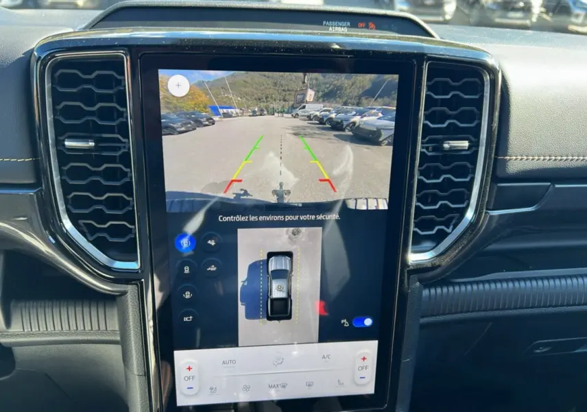Vue rapprochée de l'écran tactile central du Ford Ranger 2025 bleu lightning, affichant la caméra de recul et l'aide au stationnement.