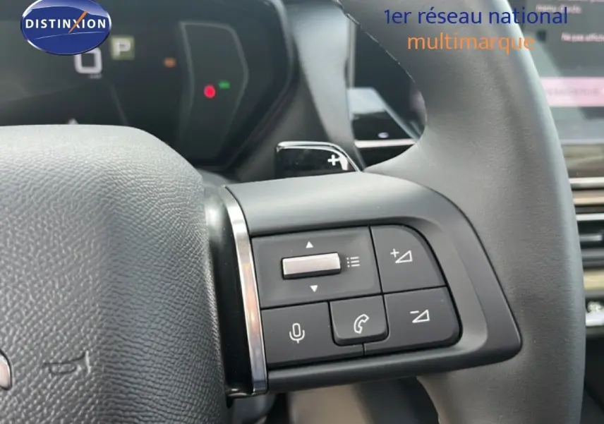 Gros plan sur les commandes au volant à droite du Citroën C5 X noir métal 2023, avec palettes de changement de vitesse visibles.