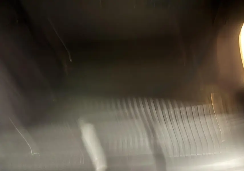 Vue intérieure floue du coffre du FIAT Scudo Fourgon gris foncé, sans détails distinctifs visibles.