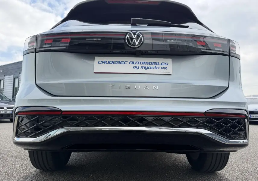 Vue arrière centrée du Volkswagen Tiguan gris métallisé 2025 avec feux LED et logo VW lumineux.