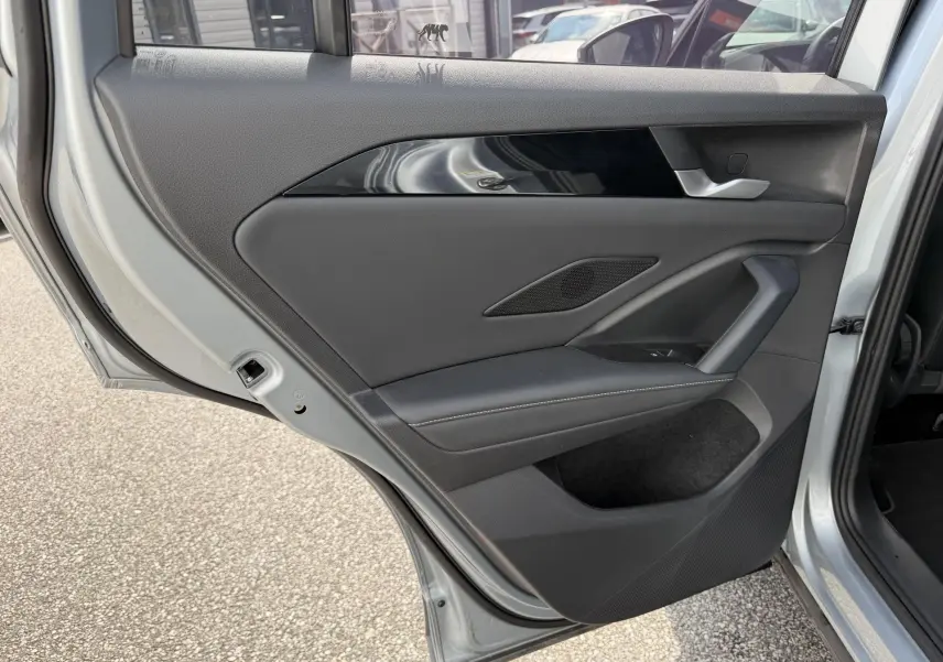 Vue rapprochée de la porte arrière gauche grise du Volkswagen Tiguan 2025 avec garniture noire et poignée intégrée.