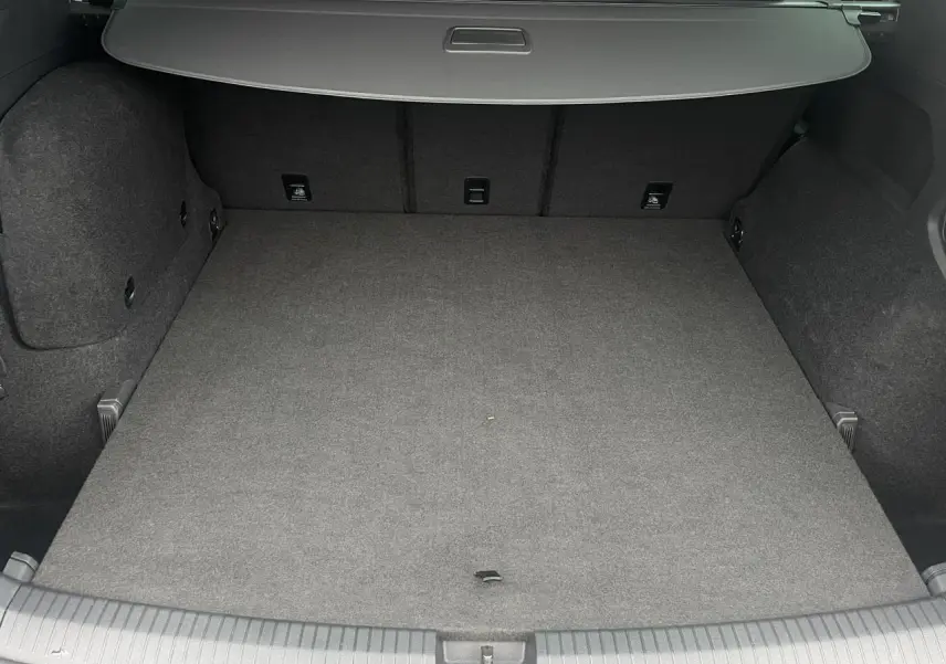 Coffre spacieux du SEAT Tarraco 1.4 e-Hybrid 245 DSG6 FR vu de l'arrière, intérieur gris foncé avec hayon fermé.