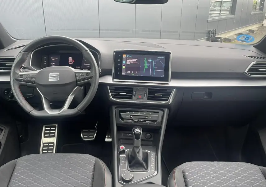 Intérieur du SEAT Tarraco 2024 avec tableau de bord moderne, volant sport et console centrale vue de face.
