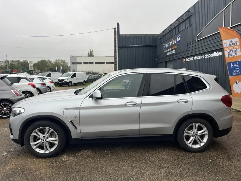 Profil côté gauche d'un BMW X3 xDrive30e hybride rechargeable 2020 en Glacier Silver avec jantes alliage 18 pouces.