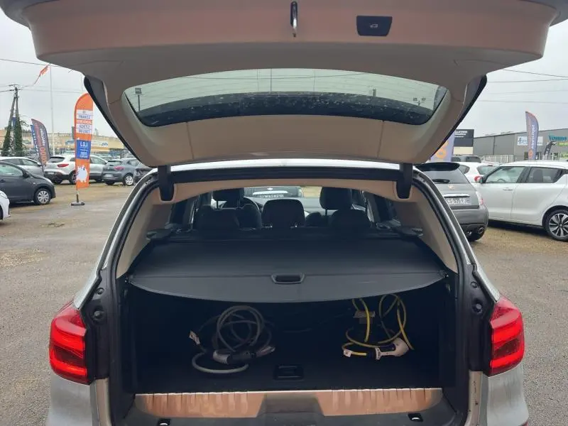 Coffre ouvert d'un BMW X3 xDrive30e GlacierSilver 2020, montrant les câbles de recharge hybrides dans le coffre.