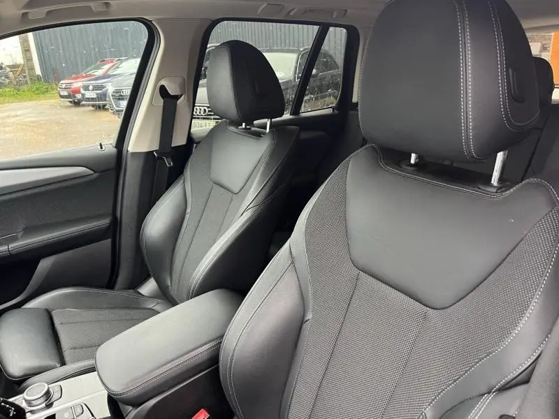 Vue rapprochée des sièges avant en tissu et cuir noir avec surpiqûres blanches dans l'habitacle du BMW X3 GlacierSilver 2020.
