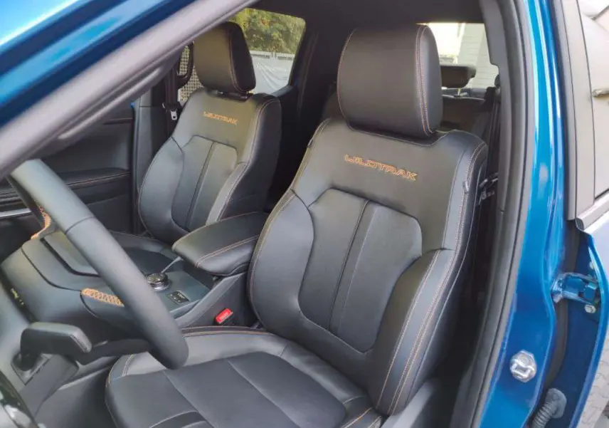 Vue intérieure côté conducteur du Ford Ranger 2025 bleu lightning, sièges en cuir noir avec surpiqûres orange Wildtrak.
