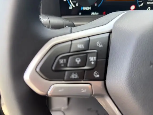 Gros plan sur les commandes multifonctions noires à gauche du volant du Volkswagen Transporter ProCab noir 2026.