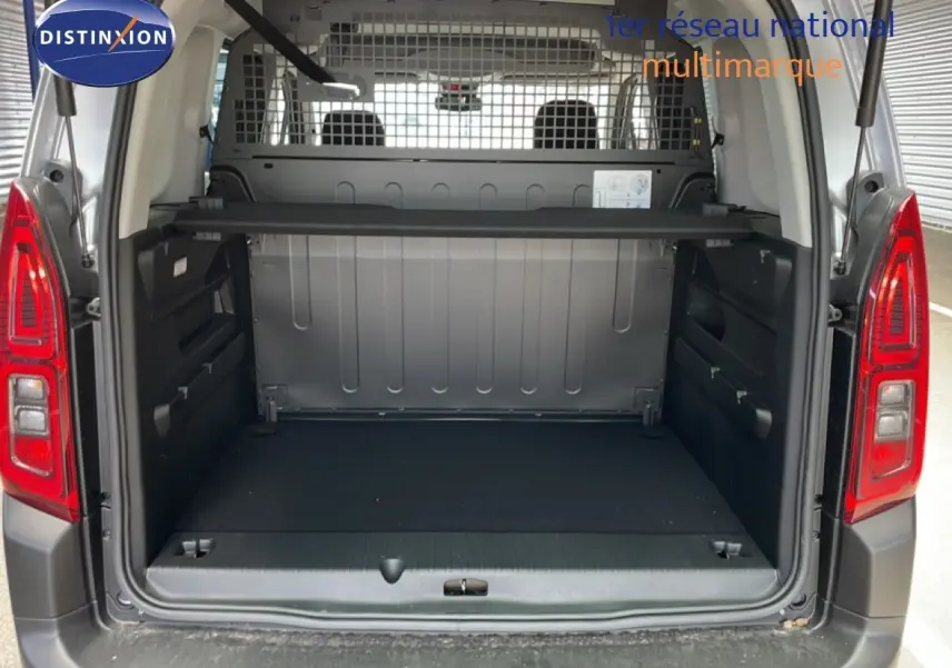 Vue arrière ouverte du Citroën Berlingo gris Artense métal, montrant le grand espace de chargement vide et la grille de séparation.
