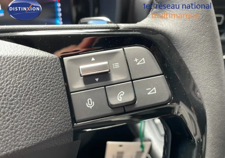 Gros plan sur les commandes multifonctions noires du volant du Citroën Berlingo gris Artense, version 2026.