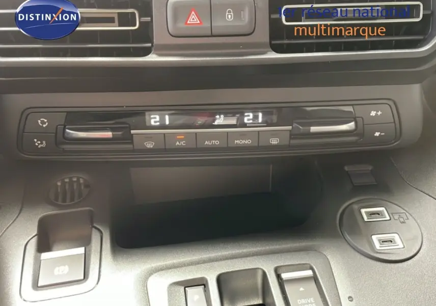 Vue rapprochée du tableau de bord du Citroën Berlingo gris, montrant la climatisation digitale et les commandes centrales.