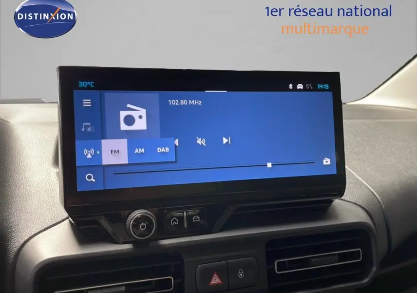 Vue rapprochée de l’écran tactile central du tableau de bord du Citroën Berlingo gris Artense, affichant la radio FM.