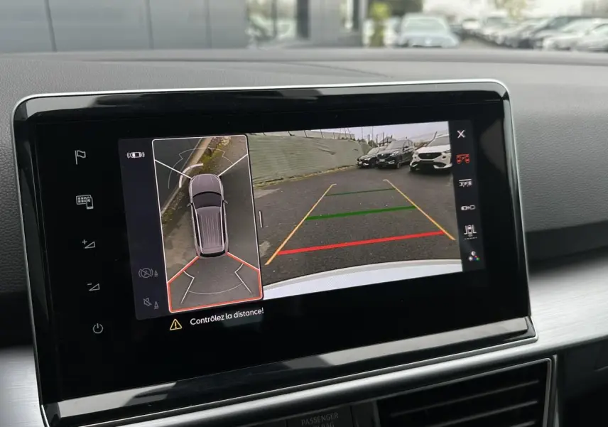 Écran tactile intérieur montrant la caméra 360° et vue arrière du SEAT Tarraco blanc Oryx en stationnement.