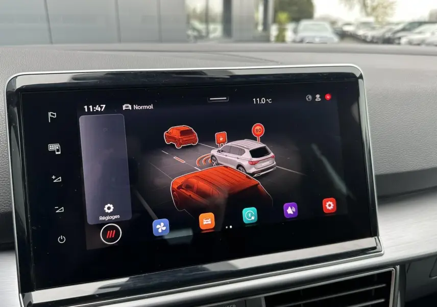 Écran tactile intérieur montrant l'assistance à la conduite avec vue 3D des véhicules et panneaux de signalisation