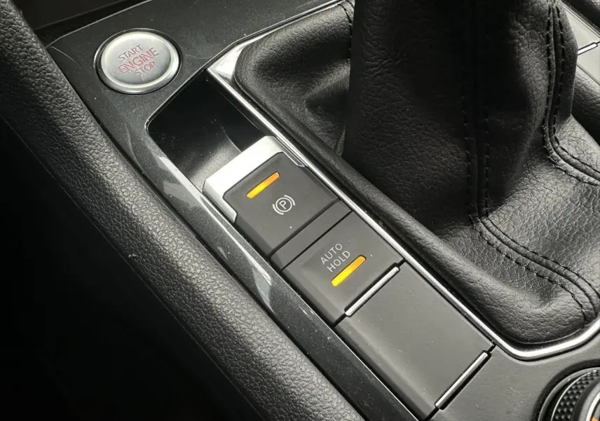 Gros plan sur la console centrale noire du SEAT Tarraco 2024, avec frein électrique et bouton start/stop visibles.