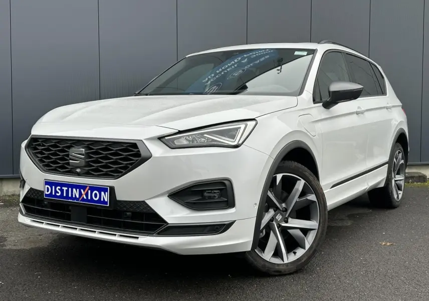 SEAT Tarraco blanc Oryx en 3/4 avant droit, avec jantes alliage 20 pouces et toit ouvrant panoramique visible.