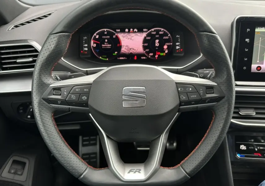 Vue rapprochée du volant sport en cuir perforé avec surpiqûres rouges du SEAT Tarraco FR 2024.