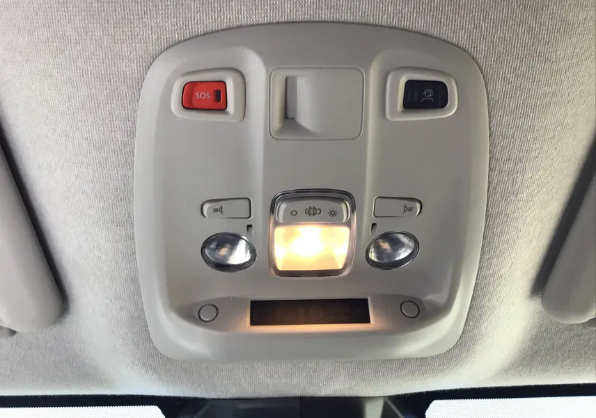 Plafonnier intérieur gris clair avec boutons SOS et éclairage central allumé dans un Peugeot Expert Fourgon blanc.