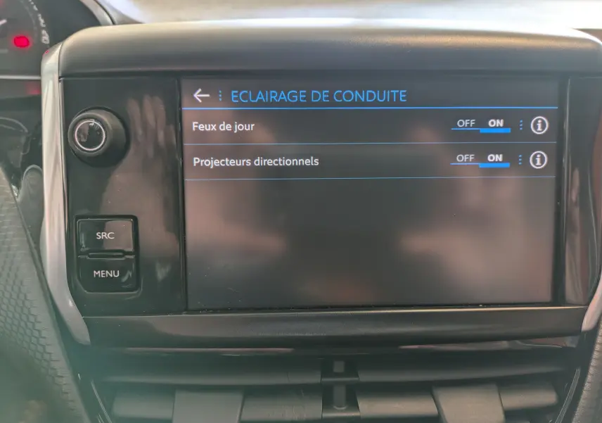 Écran tactile central de la Peugeot 208 Allure 2019 affichant les réglages d’éclairage de conduite, intérieur noir.