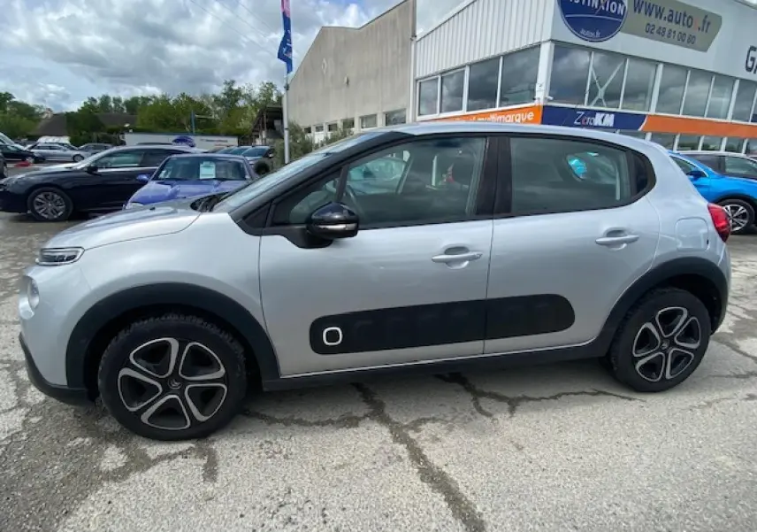 Profil côté gauche d'une Citroën C3 gris clair avec protections latérales noires et jantes 16 pouces en 3D.