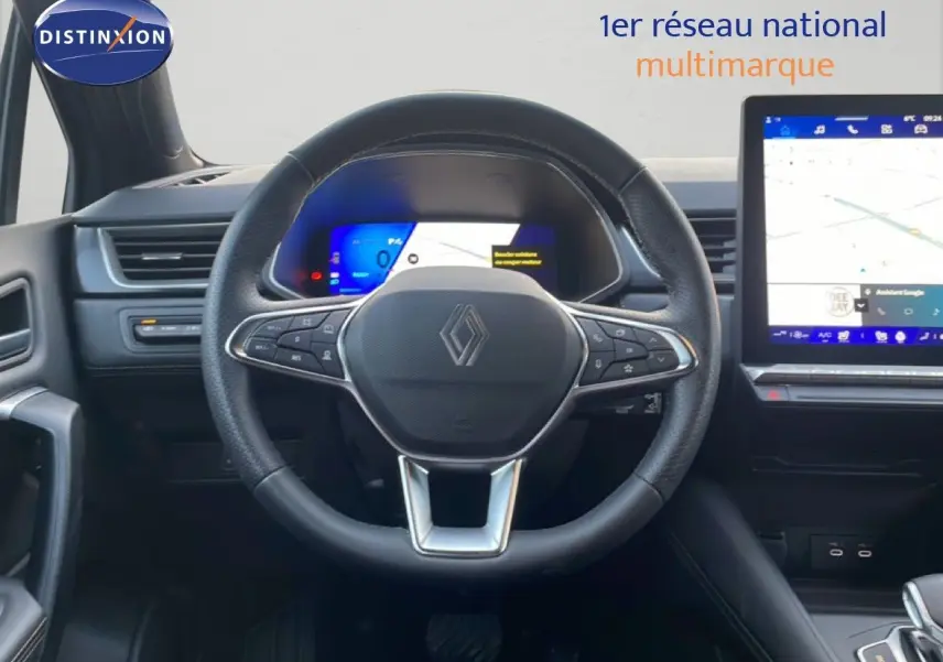 Vue intérieure centrée sur le volant Renault Symbioz gris cassiopée, avec tableau de bord numérique et écran tactile visible.