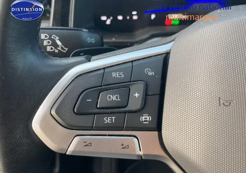 Gros plan sur les commandes au volant côté gauche du Volkswagen Polo gris cendre 2025 avec boutons de régulateur de vitesse.