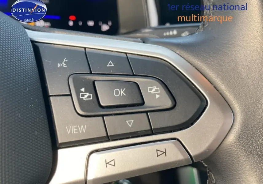 Gros plan sur les commandes multifonctions du volant cuir d’une Volkswagen Polo gris cendre, version 2025.