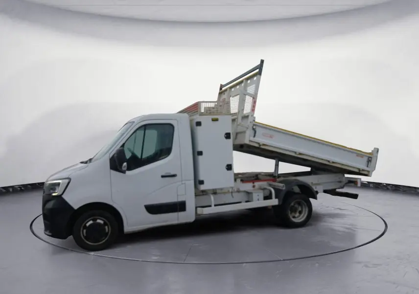 Renault Master blanc vu de profil gauche avec benne basculante relevée et coffre latéral fermé.