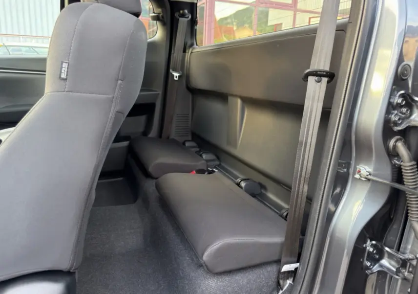 Vue intérieure côté droit sur les sièges arrière strapontins en tissu du pick-up Isuzu D-MAX gris Obsidian 2026.