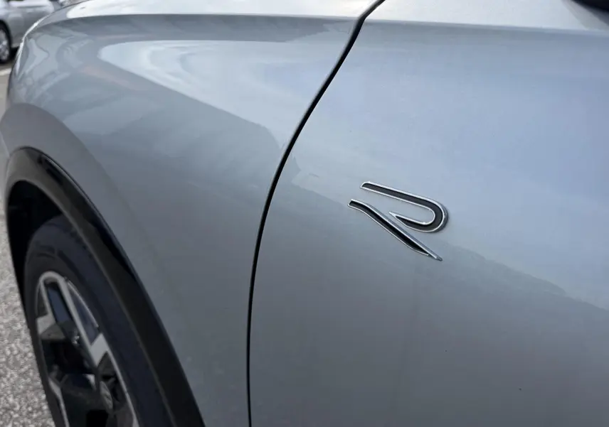 Gros plan sur l'aile avant gauche grise du Volkswagen Tiguan 2025 avec logo R distinctif.