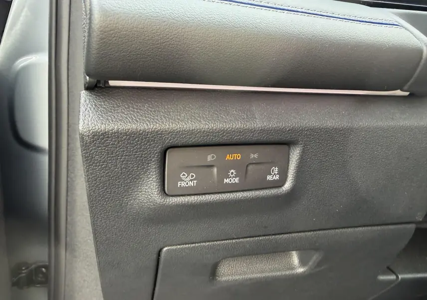 Détail du panneau de commandes d'éclairage intérieur noir du Volkswagen Tiguan 2025, avec mode automatique activé.