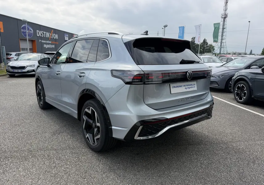 Volkswagen Tiguan gris 2025 vu 3/4 arrière droit, avec feux arrière LED 3D et jantes alliage noires.