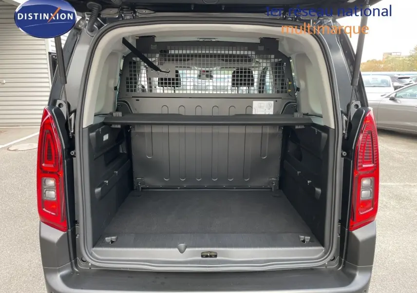 Coffre ouvert vu de l'arrière d'un Citroën Berlingo noir Perla Nera, montrant l'espace de chargement et la grille de séparation.
