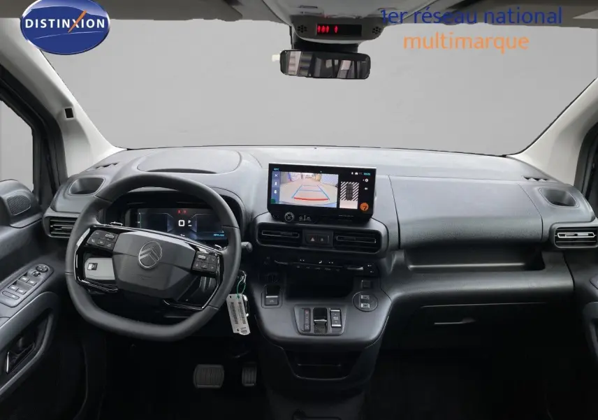 Vue intérieure avant du tableau de bord et volant du Citroën Berlingo noir, avec écran tactile affichant la caméra de recul.