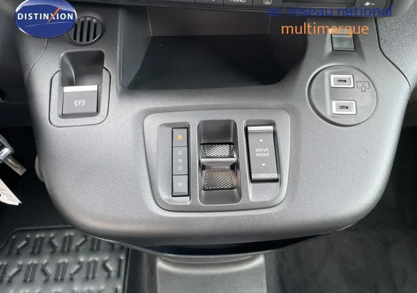Gros plan sur la console centrale noire du Citroën Berlingo 2026, avec commandes de boîte auto et ports USB visibles.
