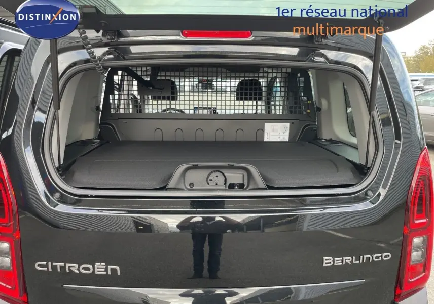 Vue arrière ouverte d'un Citroën Berlingo noir Perla Nera, montrant le coffre avec séparation grillagée et tablette de rangement.
