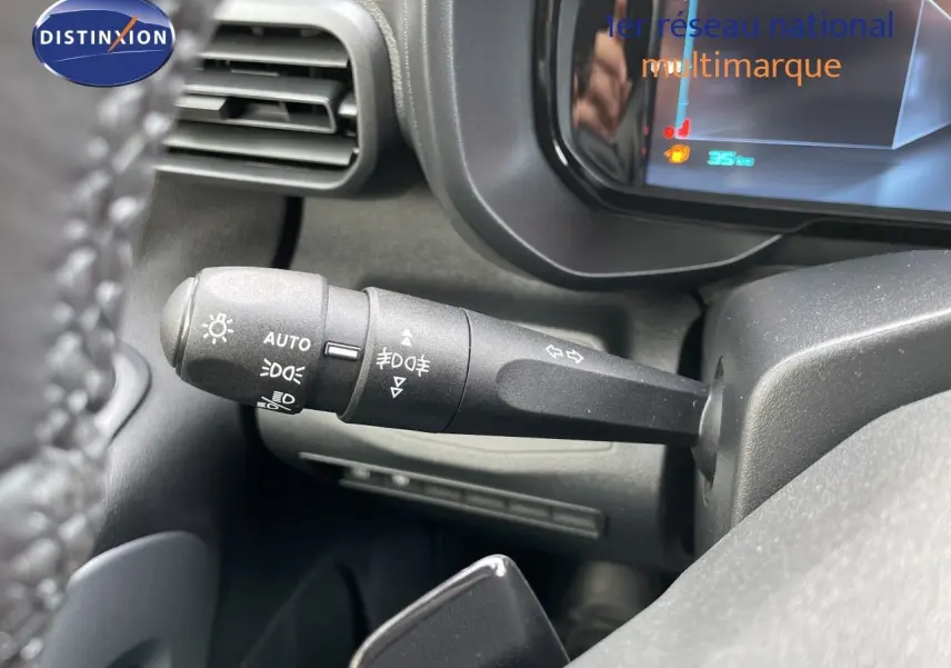 Gros plan sur la manette de clignotants à gauche du volant dans l'habitacle du Citroën Berlingo noir Perla Nera 2026.