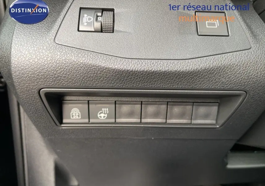 Gros plan sur les commandes de réglage de phares et de chauffage du volant dans un Citroën Berlingo noir intérieur, côté conducteur.