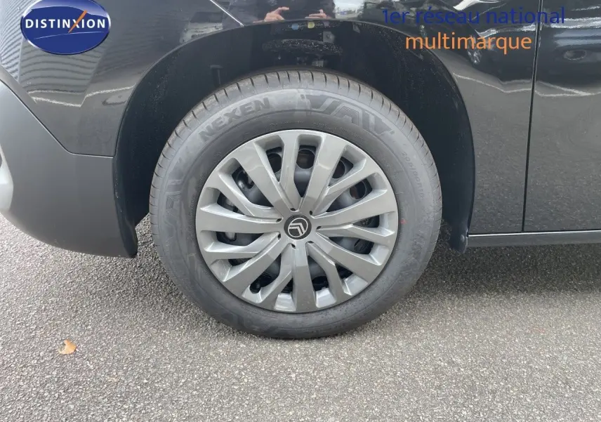 Gros plan sur la roue avant gauche noire d’un Citroën Berlingo 2026 avec enjoliveur gris et logo Citroën central.