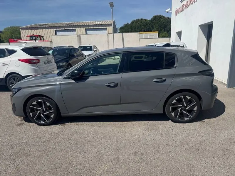 Peugeot 308 Hybrid gris vue de profil côté gauche, avec jantes alliage 17 pouces et vitres teintées.